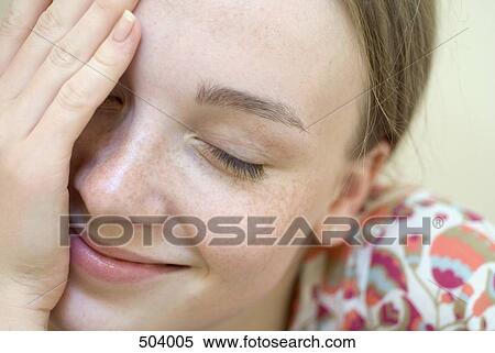 A young woman with her eyes closed and hand over her face View Large Photo Image Stock Photography - A young woman with her eyes closed and hand over her face. Fotosearch