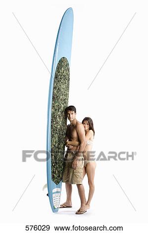 A couple standing with a surfboard View Large Photo Image Stock Photo - A couple standing with a surfboard. Fotosearch