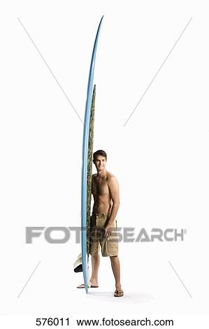 Stock Image - A man standing with a surfboard. Fotosearch
