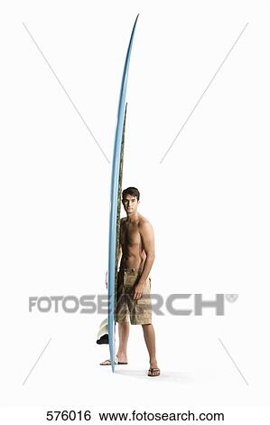 A man standing with a surfboard View Large Photo Image Stock Photograph - A man standing with a surfboard. Fotosearch