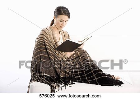 A woman wrapped in a blanket and reading a book View Large Photo Image Stock Photography - A woman wrapped in a blanket and reading a book. Fotosearch