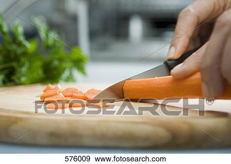 Close up of hand chopping carrot View Large Photo Image Stock Photo - Close up of hand chopping carrot. Fotosearch