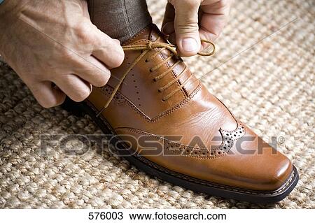 Close up of hands tying shoelace View Large Photo Image Stock Image - Close up of hands tying shoelace. Fotosearch