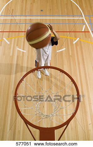 Stock Image - A basketball being shot in a basketball hoop. Fotosearch