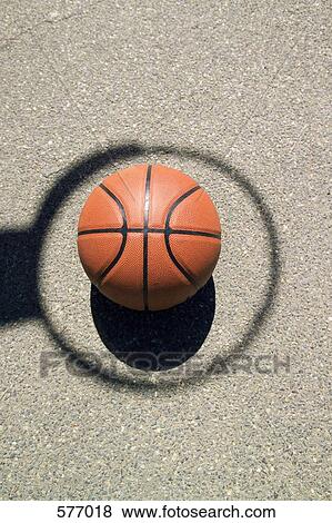 A basketball in the middle of a shadow hoop View Large Photo Image Stock Photo - A basketball in the middle of a shadow hoop. Fotosearch