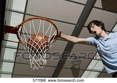 A man making a slam dunk in a basketball hoop View Large Photo Image Stock Photo - A man making a slam dunk in a basketball hoop. Fotosearch