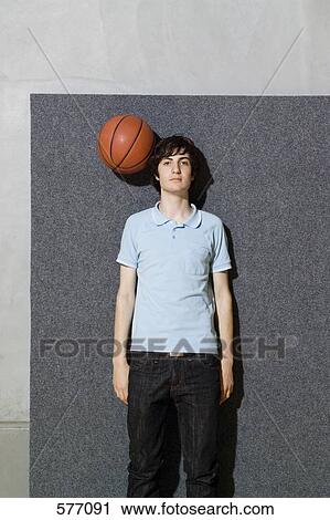 A man standing with a basketball by his head View Large Photo Image Stock Image - A man standing with a basketball by his head. Fotosearch