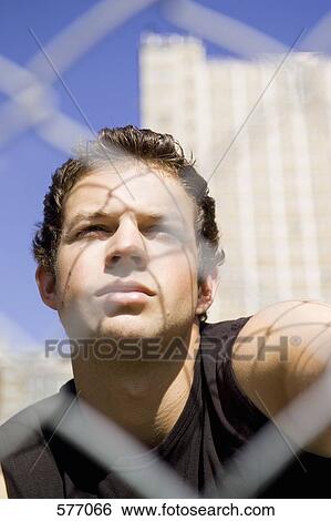 A young man behind a defocused chainlink fence View Large Photo Image Stock Photograph - A young man behind a defocused chainlink fence. Fotosearch