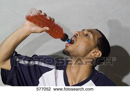 Stock Image - A young man drinking a sports drink. Fotosearch