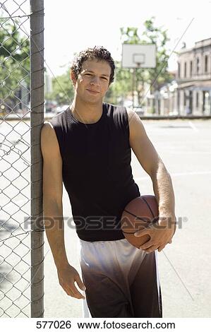 A Young man holding a basketball at an outdoor court View Large Photo Image Stock Photograph - A Young man holding a basketball at an outdoor court. Fotosearch