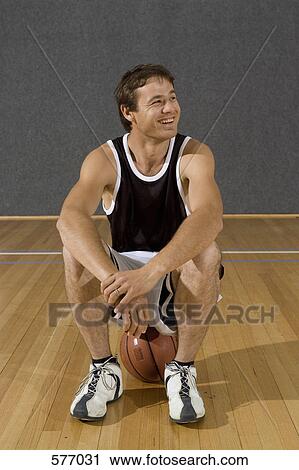A young man sitting on a basketball View Large Photo Image Stock Image - A young man sitting on a basketball. Fotosearch
