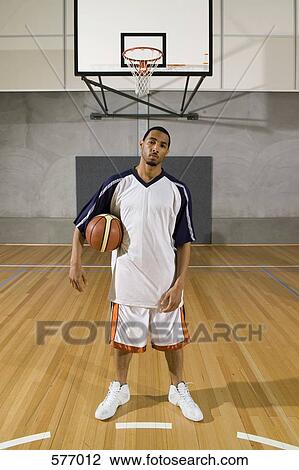 A young man standing on a basketball court with a basketball View Large Photo Image Stock Image - A young man standing on a basketball court with a basketball. Fotosearch