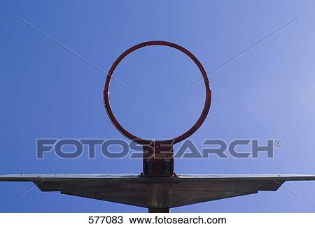 Stock Image - low angle view through a basketball hoop of the sky. Fotosearch