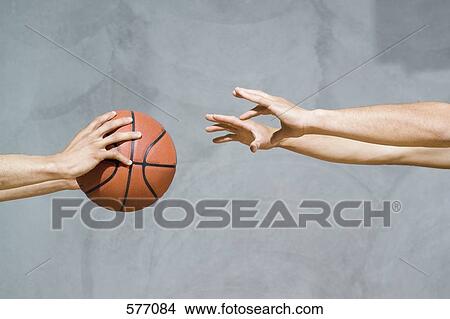 Picture - Two sets of human arms passing a basketball. Fotosearch