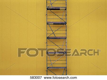 Scaffolding against a yellow wall View Large Photo Image Stock Photo - Scaffolding against a yellow wall. Fotosearch