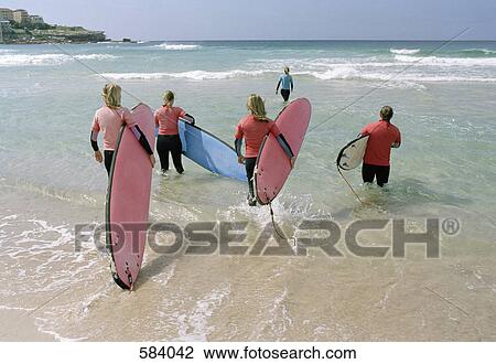 Rear View of a group of surfers standing on the shore and looking towards the horizon View Large Photo Image Stock Image - Rear View of a group of surfers standing on the shore and looking towards the horizon. Fotosearch