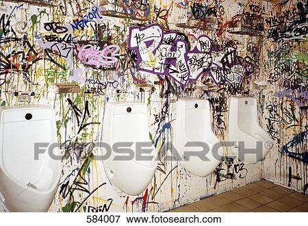 Urinals on a graffiti covered wall View Large Photo Image Stock Photo - Urinals on a graffiti covered wall. Fotosearch