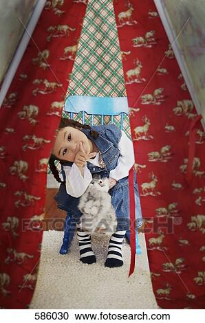 A young girl holding a stuffed toy peeks through a tent doorway and points View Large Photo Image Stock Image - A young girl holding a stuffed toy peeks through a tent doorway and points. Fotosearch