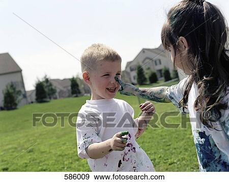 A young girl touching a boy's nose with paint splattered finger View Large Photo Image Stock Photo - A young girl touching a boy's nose with paint splattered finger. Fotosearch