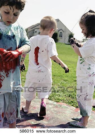 Three children playing in paint splattered clothes View Large Photo Image Stock Photography - Three children playing in paint splattered clothes. Fotosearch