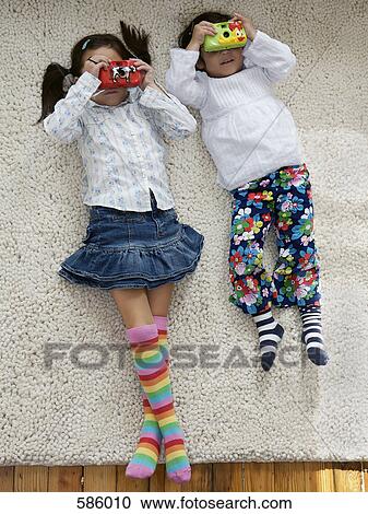 Two young girls holding toy cameras up to their faces View Large Photo Image Stock Image - Two young girls holding toy cameras up to their faces. Fotosearch