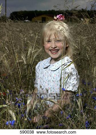 A girl standing in a wheat field View Large Photo Image Stock Photo - A girl standing in a wheat field. Fotosearch