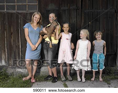 A row of children standing in a row with a goat View Large Photo Image Stock Image - A row of children standing in a row with a goat. Fotosearch