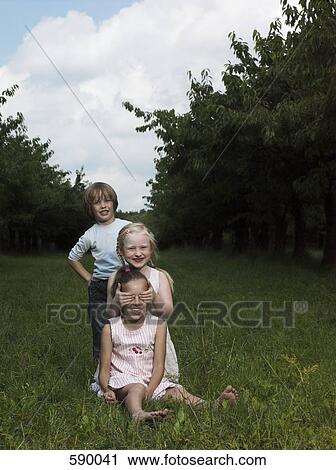 Stock Image - Three children in a garden. Fotosearch