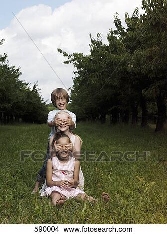 Three children playing in a field View Large Photo Image Picture - Three children playing in a field. Fotosearch