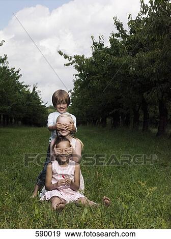 Stock Photo - Three children playing in a field. Fotosearch