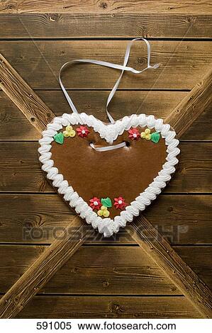 A heart shaped cookie hanging on a wooden wall View Large Photo Image Stock Photography - A heart shaped cookie hanging on a wooden wall. Fotosearch