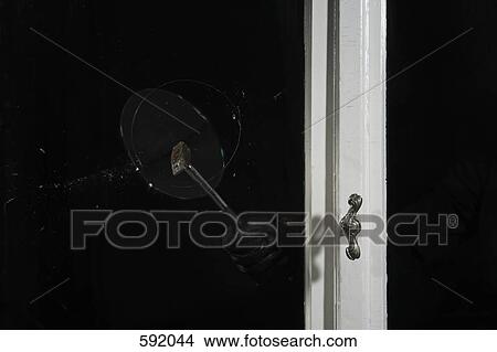 A gloved hand breaking a window with a hammer View Large Photo Image Picture - A gloved hand breaking a window with a hammer. Fotosearch