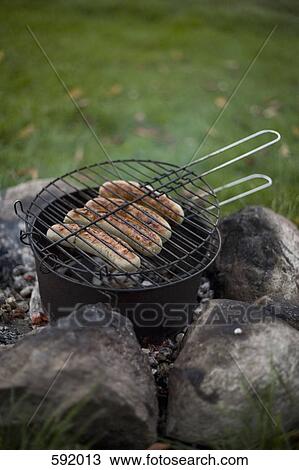 Sausages cooking on a camp fire View Large Photo Image Stock Image - Sausages cooking on a camp fire. Fotosearch