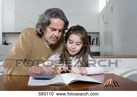 A father helping his daughter with her homework View Large Photo Image Stock Image - A father helping his daughter with her homework. Fotosearch