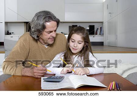 A father helping his daughter with her homework View Large Photo Image Stock Photography - A father helping his daughter with her homework. Fotosearch
