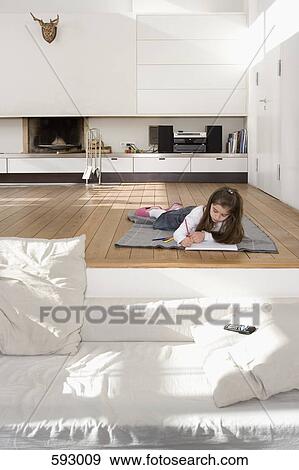 A little girl lying on the floor and drawing View Large Photo Image Stock Photo - A little girl lying on the floor and drawing. Fotosearch