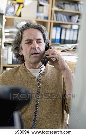 A man using a landline phone View Large Photo Image Picture - A man using a landline phone. Fotosearch