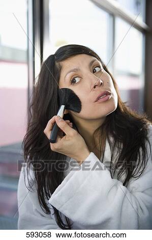 Stock Photo - A woman applying face powder. Fotosearch