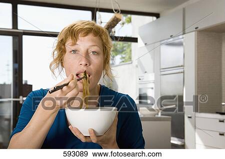 A woman eating stir-fry View Large Photo Image Stock Photo - A woman eating stir-fry. Fotosearch