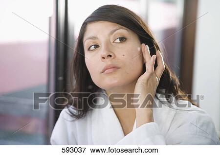 Stock Photo - A woman looking in the mirror. Fotosearch