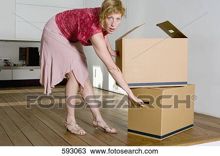 A woman moving cardboard boxes View Large Photo Image Stock Image - A woman moving cardboard boxes. Fotosearch