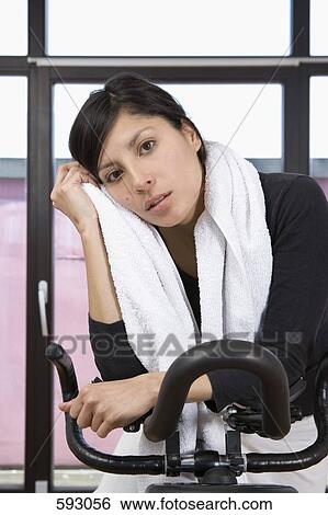 Stock Photograph - A woman on an exercise bike. Fotosearch