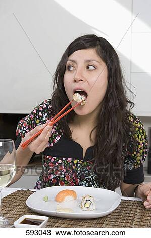 A young woman eating sushi View Large Photo Image Stock Image - A young woman eating sushi. Fotosearch