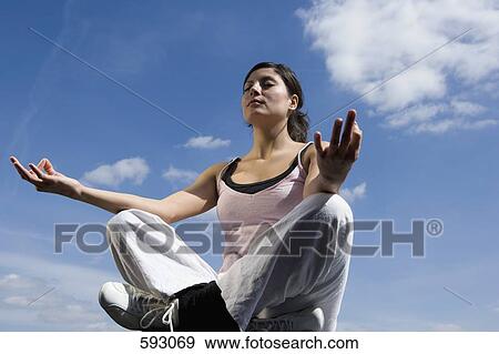 A young woman meditating View Large Photo Image Stock Photo - A young woman meditating. Fotosearch