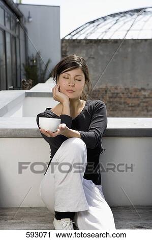 A young woman relaxing on a rooftop garden View Large Photo Image Stock Image - A young woman relaxing on a rooftop garden. Fotosearch