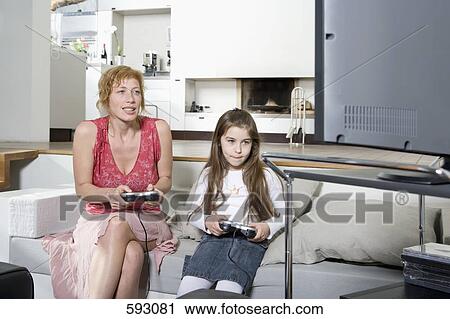 Mother and daughter playing a video game together View Large Photo Image Stock Image - Mother and daughter playing a video game together. Fotosearch