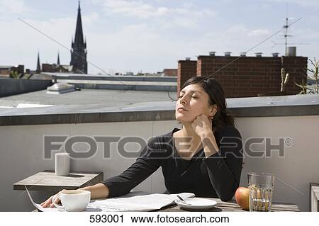 Woman sitting on a rooftop in the sun View Large Photo Image Stock Image - Woman sitting on a rooftop in the sun. Fotosearch