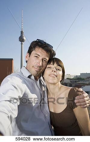 Stock Photo - A couple photographing themselves on a rooftop terrace. Fotosearch