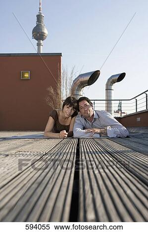 Portrait of a man and a woman lying together on a rooftop terrace View Large Photo Image Stock Photography - Portrait of a man and a woman lying together on a rooftop terrace. Fotosearch