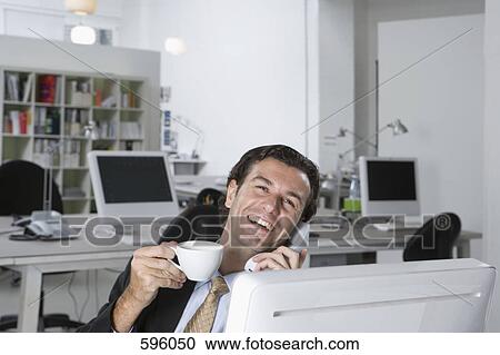 Stock Image - A businessman on the phone in an office. Fotosearch